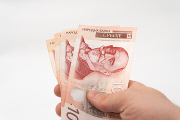 Man holding pile of money 1000 RSD Serbian Dinar banknote paper currency isolated on white...