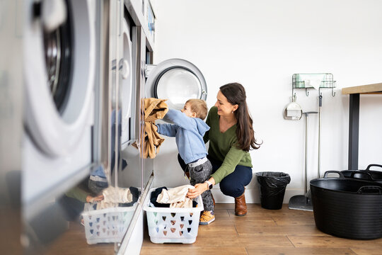 Mother and little boy doing laundry