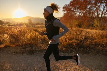 Woman running in countryside at sunrise