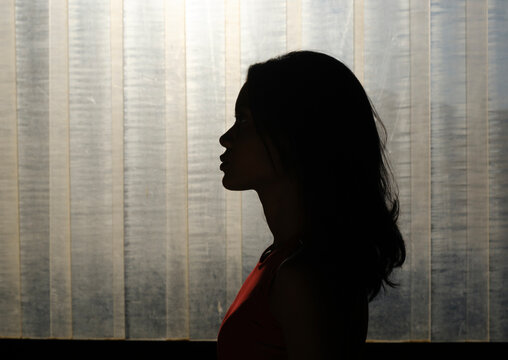 Woman posing in profile over plastic curtain