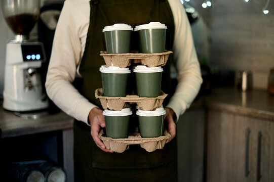 stack takeaway coffee in male's hands