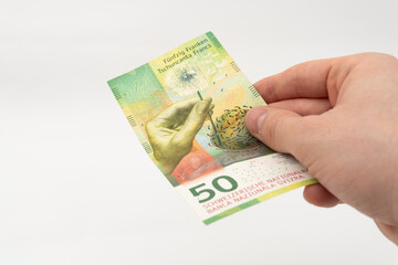Man holding 50 CHF Swiss franc banknote paper currency isolated on white background