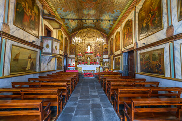 Interior nave and pews of the 15th century Nossa Senhora da Conceição Chapel, or Our Lady of Conception Chapel, in the old town of the fishing village of Camara de Lobos, Portugal, on Madeira Island.