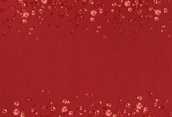 Red festive paper background with glitter confetti
