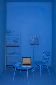 A mockup with a laptop screen in a monochrome blue room in 3d style