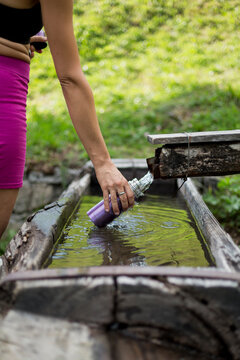 woman fills the bottle canteen with water