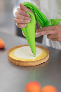 Confectioner Preparing a cake with pastry bag
