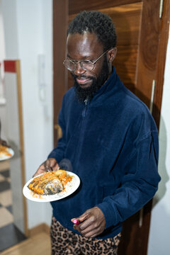 Man holding plate with food.