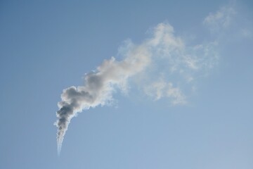 : Smoke curling upwards against clear sky