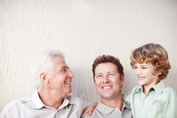 Hug, father and grandfather or son with smile for bonding, love or relax with generations by wall....