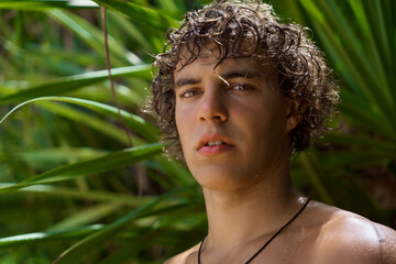 portrait of a handsome guy in tropical greenery.