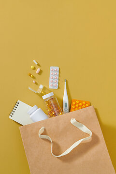 Paper bag with different pills, syringe and bottles of medicine