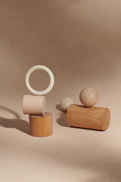 Composition of wooden podium and geometric shape objects on beige