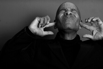deaf man suffering from deafness and hearing loss on grey black background with people stock image...