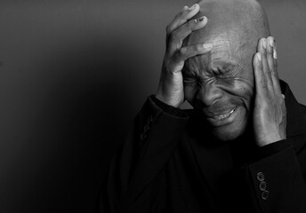 deaf man suffering from deafness and hearing loss on grey black background with people stock image...
