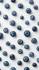 Organically arranged fresh blueberries on a clean white background creating a repetitive pattern