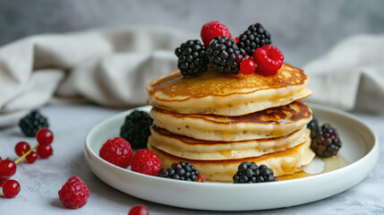 Homemade pancakes on white plate with berries. Tasty breakfast