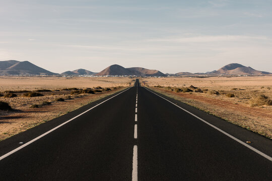 Straight road between volcanoes and desert.