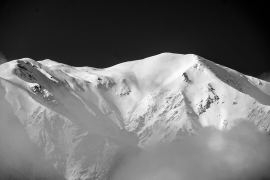 Light hitting mountain peaks with fog