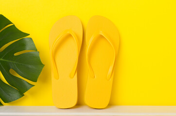 Bright yellow flip-flops on table. Summer concept