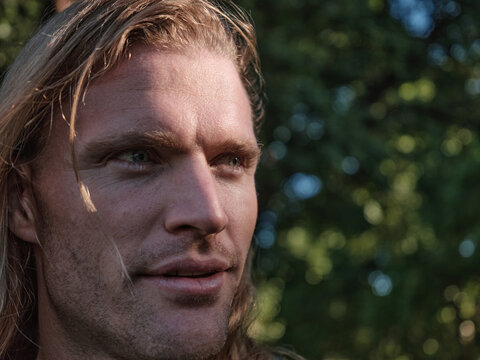 Dark close up portrait of man with long hair