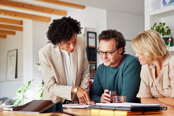 Financial advisor showing investment to couple at home