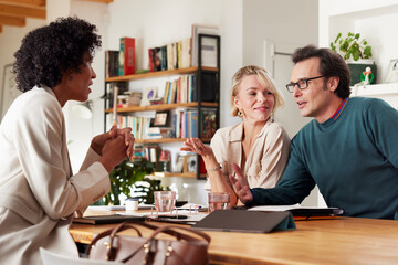 Happy couple discussing financial plan with consultant at home