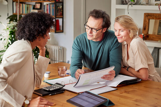 Happy couple having finance discussion with consultant at home