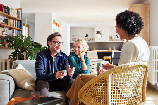 Smiling couple with female insurance agent at home