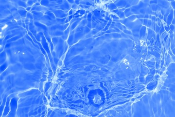 Transparent blue water surface with ripples. Water waves with sunlight. For cosmetic ads