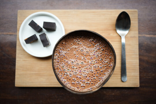Hot cocoa in coconut shell with artisanal chocolates, ceremony