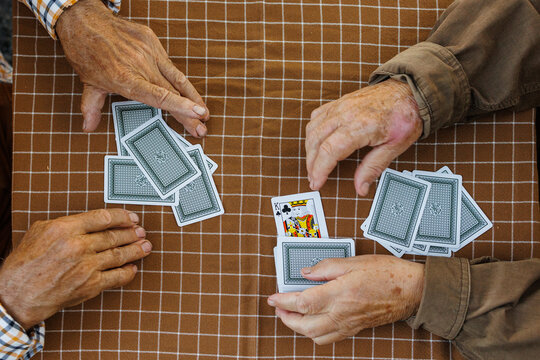 An elderly couple playing a casual card game at the table