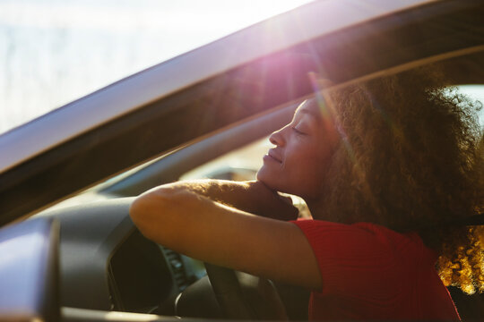 Woman resting in car at sunlight