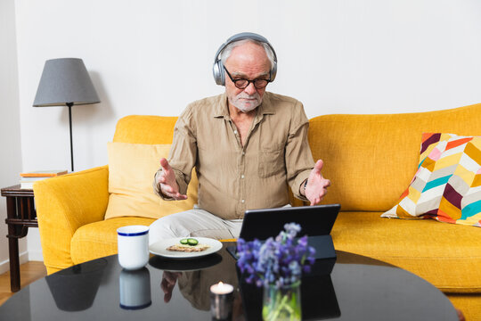 Man excitedly waves while video chatting on his tablet