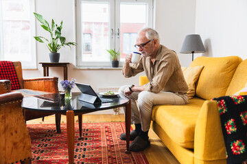A man uses a tablet at home