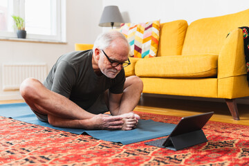 Aged man following online workout class