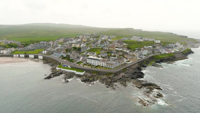 Aerial orbit view of Kilkee, small coastal town, popular as a seaside resort, located in horseshoe bay and protected from the Atlantic Ocean by the Duggerna Reef, county Clare, Ireland.