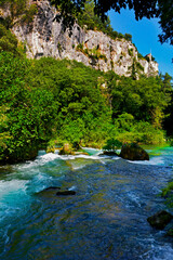 spieniona woda w górskim strumieniu, turkusowa woda w górskim potoku w Prowansji, zielone krzewy otaczajace górski strumień z lazurową wodą, turquoise water in a mountain stream, Provence, France - obrazy, fototapety, plakaty