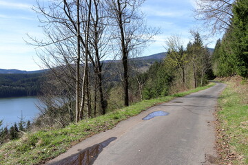 A road with a view of the lake. Sunny spring day in the mountains.
