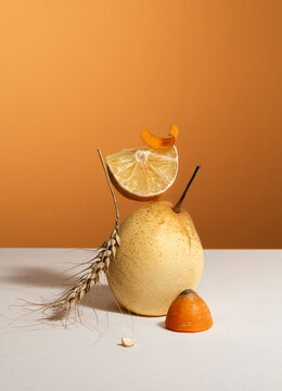 Natural still life. Pear, lemon, carrot slice, and dried ear of wheat
