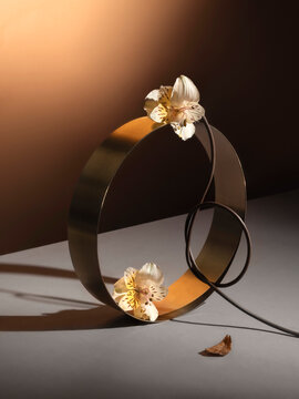 Copper colored metallic ring with flowers and wires in studio lighting