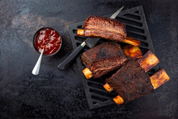 Traditional barbecue burnt chuck beef ribs marinated with spicy rub and served as top view on a...