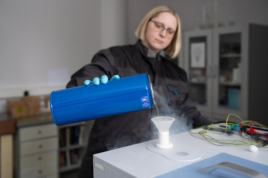 Researcher Filling The Vessel With Liquid Nitrogen.