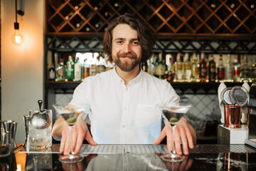 Friendly Bartender Serving Cocktails at Stylish Bar