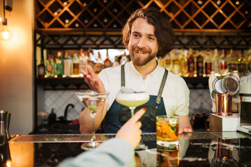 Friendly Bartender Serving Cocktails at a Busy Bar