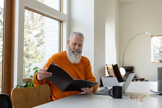 Looking at Pamphlet With Laptop