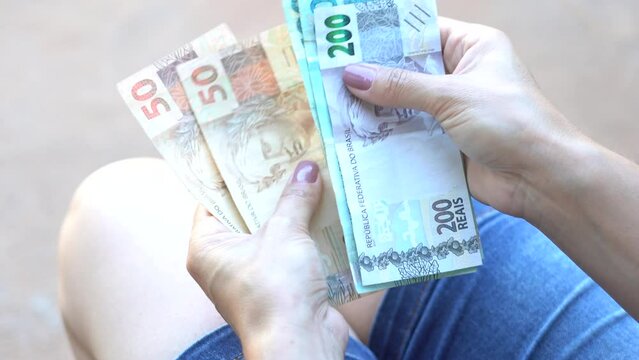 Woman holds some fifty, one hundred and two hundred reais notes, Brazilian money. According to official data, the average household income per capita (per person) increased in Brazil