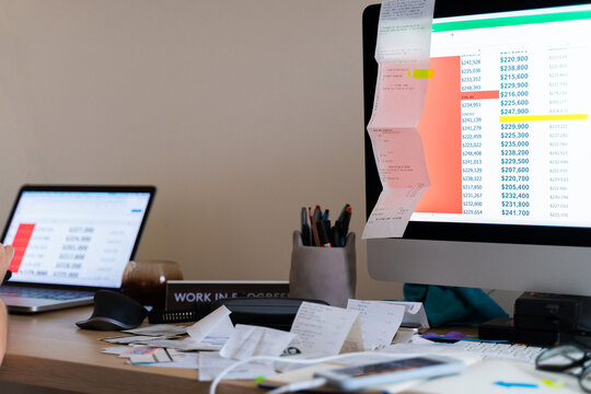 Messy workplace with receipts, invoices, papers, and checks. UGC.