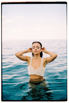 Film summer photo of young woman standing in the sea, relaxation mode