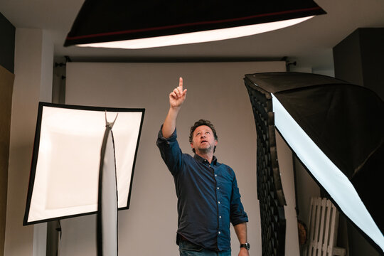 Man photographer pointing finger at softbox